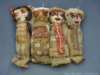 Four cloth dolls laid side by side, full view