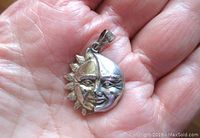 Front view of the sterling silver moon and sun face pendant showing detailed facial features and dimensional craftsmanship.