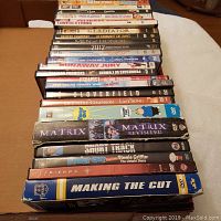 Photo of 30 assorted DVDs stacked showing a variety of movie and TV series titles across multiple genres.