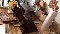 Show the Presto pressure cooker, wooden trays, ceramic canisters, cookie jar, knife block, paper towel holder on wooden countertop