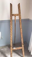 Full view of the carved wooden easel showing its overall shape and height.