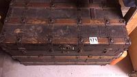 Top and side view of vintage steamer trunk showing wear, scratches and metal bands