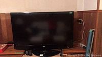 Front view of LG 42-inch TV on its swivel stand with remote on table