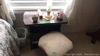 Wooden storage stand with items on top and swivel stool in front