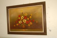 Full view of the framed floral oil painting on a wall with visible tags.