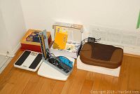 Overall view of lot showing digital scale, sphygmomanometer, brown leather case, and unopened cupping kit box.