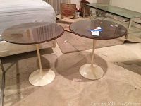 Pair of pedestal tables shown from front on carpeted floor