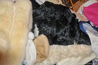 Close-up of black and beige fur dress coat showing texture and trim detail.