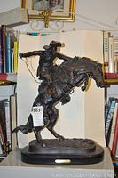 Full front view of the cowboy and horse sculpture on shelf background