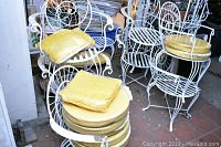 Overview of four chairs grouped together with cushions stacked on seats