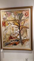 Full view of framed abstract oil painting showing tree, boats, birds, and other shapes in warm colors.