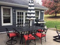 Full outdoor set on patio showing table, chairs, umbrella and base