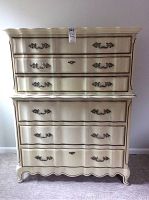 Front view of the two-piece cream-colored Bassett Furniture dresser showing drawer configuration and ornate metal handles, with wear visible on surface and edges.