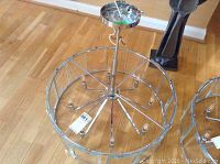 Full view of ceiling fixture showing circular frame, multiple bulb arms, and mounting rod.