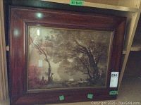 Photo of the framed Corot print showing landscape scene with large trees and a water body in the background.