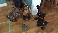 Group of animal figures including composite owl on base, composite beaver, cast iron rabbit, and three black metal ducks