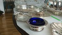 8 pieces including silver plated trays, ice bucket, and serving pieces displayed on a table, showing overall set.