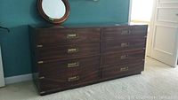Full front view of eight-drawer dresser showing brass recessed handles and mahogany finish