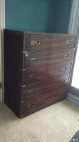 Front view showing five drawers, mahogany finish, brass recessed pulls and corner brackets
