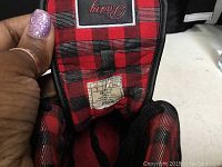 Close-up of the inside tongue label showing size 3 and tartan fabric lining.