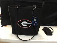 Black Georgia Bulldogs purse with logo, hanging tag visible, showing overall front and strap details
