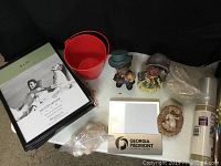 Overview of photo frames, ceramic figurines, red bucket with aquarium sand and sea shells, plastic aquarium cups, and one framed wall art drawing.