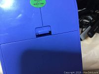 Back view showing sewing machine back panel with battery compartment and power cords.