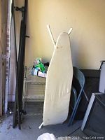 Photo of ironing board next to metal wire shelving unit