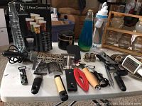 Photo of assorted kitchen utensils, two container sets, wine bottle openers, and a decorative bottle with blue liquid.