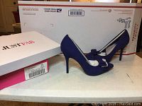 Pair of Just Fab Federica cobalt blue bow pumps next to the original box and a USPS mailing box in background.