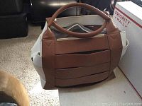 Front view of the brown and beige JustFab handbag showing design and handle structure.