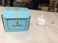 Lladro blue box and the porcelain bell ornament displayed on table.