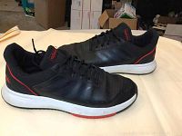 Side view of Adidas black men's sneakers size 12 showing overall condition, design details, and wear.