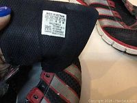 Close-up photo of the size tag inside the sneaker showing size US 12, made in Vietnam, for male.