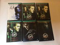 Multiple DVD cases from the TV show 24, showing seasons 1 through 4 and different disc numbers with front covers featuring Kiefer Sutherland.