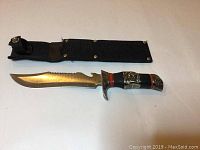 Full view of the hunting knife and accompanying black fabric sheath on white background