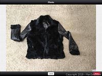 Black coat laid flat showing front side with rabbit fur lining on front, collar, and cuffs.