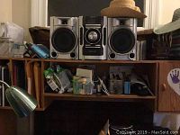 Sony Mini HiFi 3 disk CD changer component system MHCEC55 on a wooden shelf with two speakers and various items around.