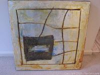Full view of one square abstract oil painting displaying intersecting lines and a dark rectangular shape with silver leaf accents