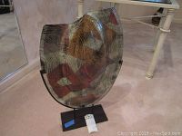 Angled front view of the large abstract art glass vase with tortoise shell pattern on custom black metal base.