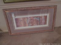 Framed, matted color lithograph artwork in pinkish wooden frame leaning against wall showing full artwork and frame.