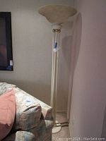 Full view of the tall floor lamp next to a couch showing its overall height and design