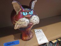 Front angle of the iridescent cat sculpture showing chubby cheeks and detailed facial features.