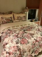 Full bed setup with floral comforter, matching pillows, and visible lamp shades showing floral pattern