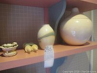Photo showing Lenox dragonfly trinket box, small ceramic urns, and lidded vase on display shelf.
