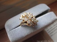 Top/front view of ring on display stand showing diamond cluster