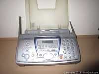 Panasonic KX-FPG381 fax machine, close-up photo showing front control panel with numeric keypad, LCD screen, and function buttons.