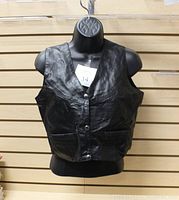 Black leather women's vest displayed on black mannequin, front view shows button closure and front pockets.