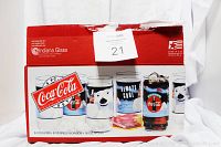 Photo of the original red and white box containing the set of 8 Coca Cola glasses, with images of the different glass designs on the front.