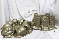 Two cake pans: castle Bundt cake pan and smiling caterpillar cakelet pan, metallic finish